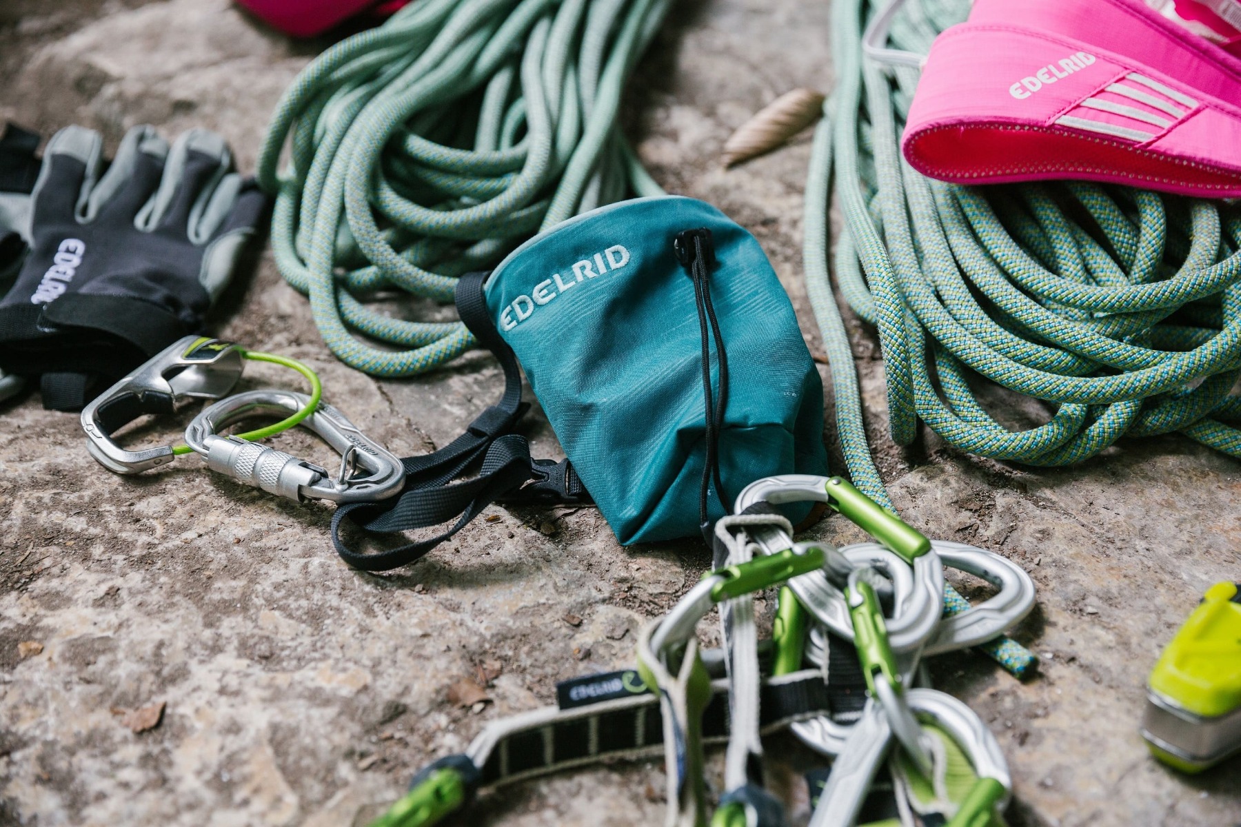 岩の上に置かれたロープ、カラビナ、手袋、チョークバッグ — Edelrid