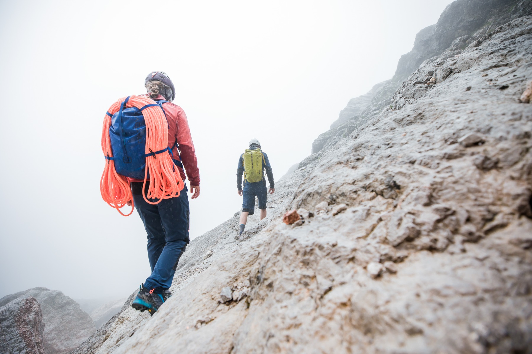 ORTOVOX DRYのバックパックを背負い、岩の斜面を登る2人の登山者