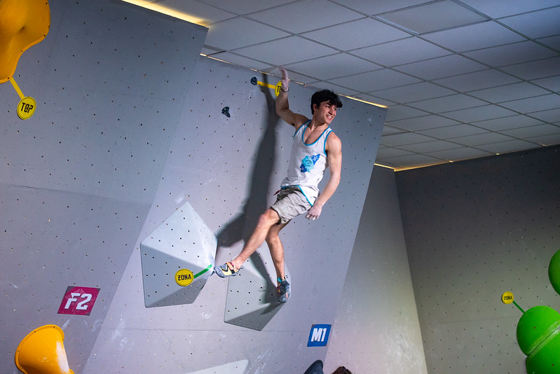 PratoのCrazy Centerでボルダリング壁のトップに到達する男子選手