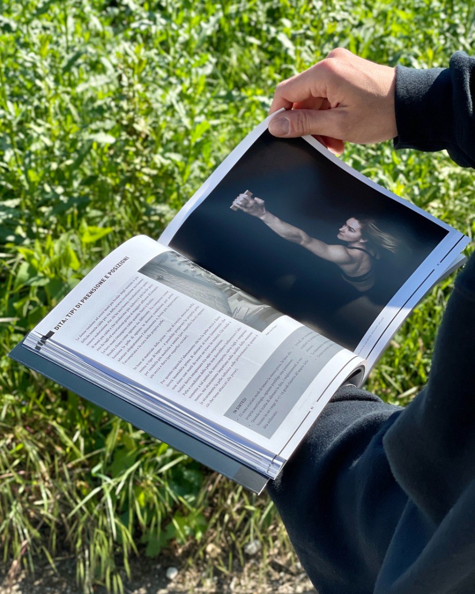 屋外で『Beastmaking』の写真入りページを開いている様子