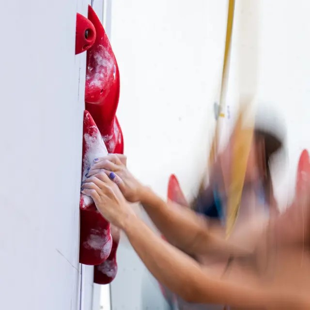 人工クライミング壁の赤いホールドにかけた手 — IFSC Media Gallery