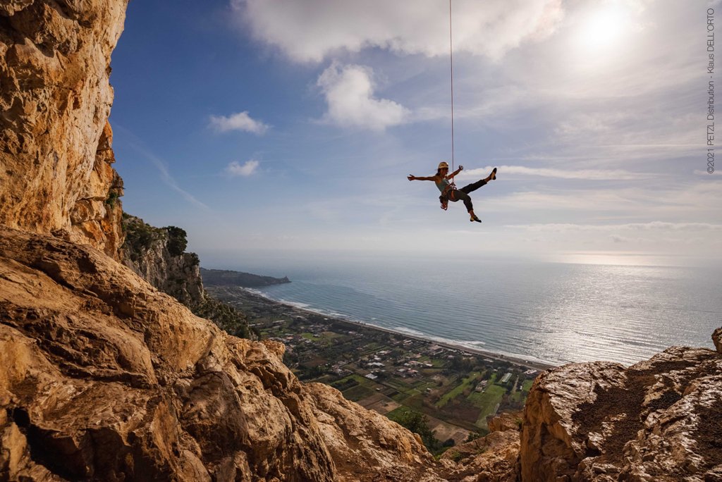 Petzl Legend Tourの写真に写る海上の岩場のクライマー