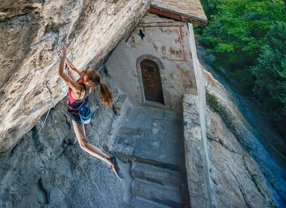 Eremo di San Paolo脇の壁を、ロープとハーネスを着けて登るLaura Rogora