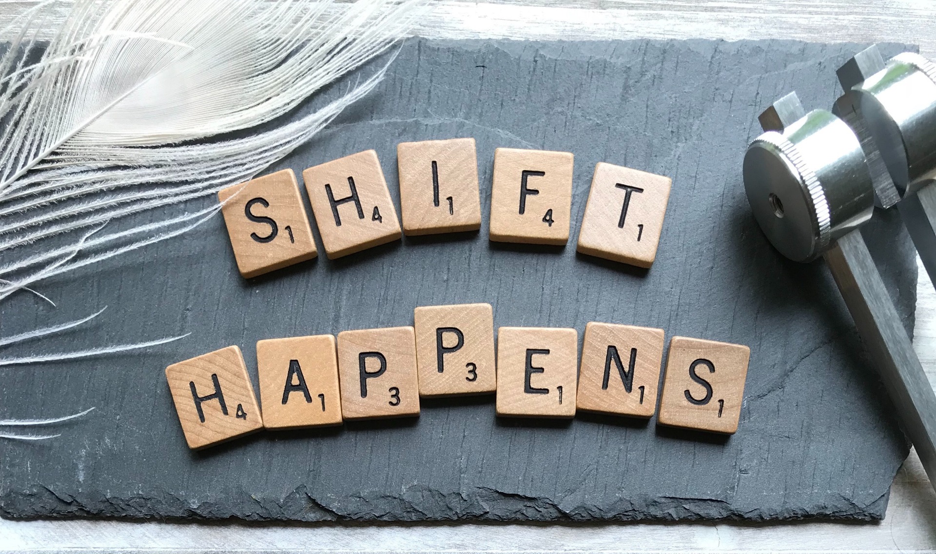 ダンベルと羽の横に、SHIFT HAPPENSと並べた文字のタイル