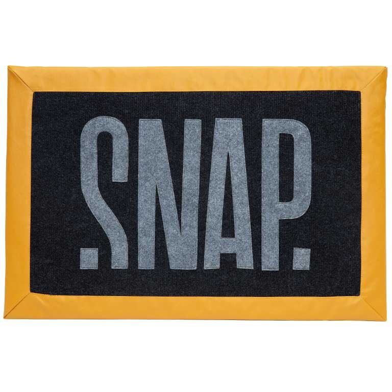 黒いパネルと灰色の「SNAP」ロゴがある、小さな黄色の長方形クラッシュパッド。