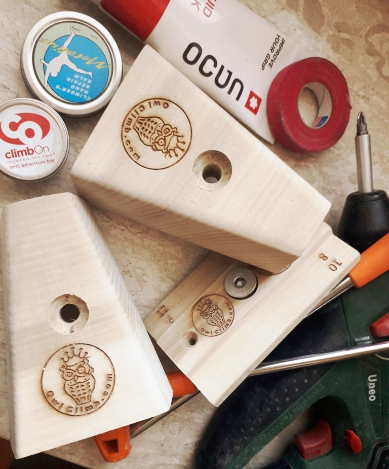 Owl Climb のロゴがある木製のトレーニングホールド、台の上の工具と小物
