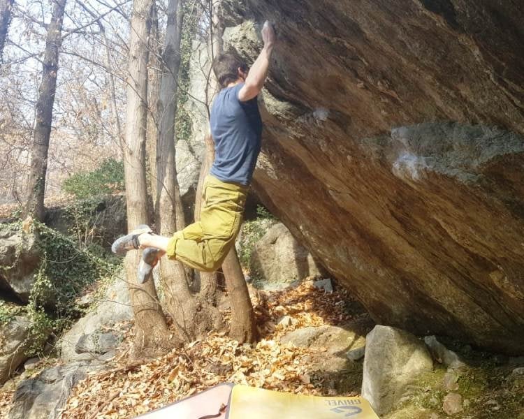 no foot climbing 森林のオーバーハングした岩で、足を浮かせて登る人。下にはクラッシュパッドがある