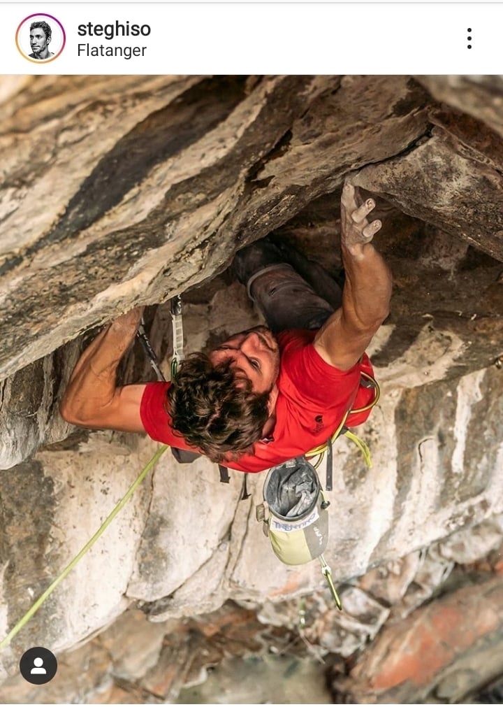Stefano GhisolfiがFlatangerのChange 9b+を再登 赤いTシャツの人物が、ハーネス、ロープ、チョークバッグを装備して岩のルーフの下を登る様子;Instagramの画面
