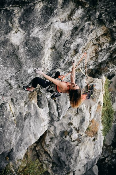 Emma Vallania, photo credits Paolo Sartori 黒いパンツをはいた人が、ロープとクイックドローを使って前傾した岩壁を登っている