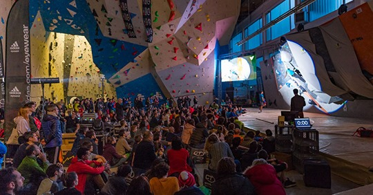 Milano Climbing Expo クライミングジムのイベントで、ボルダリング壁の前に座る観客